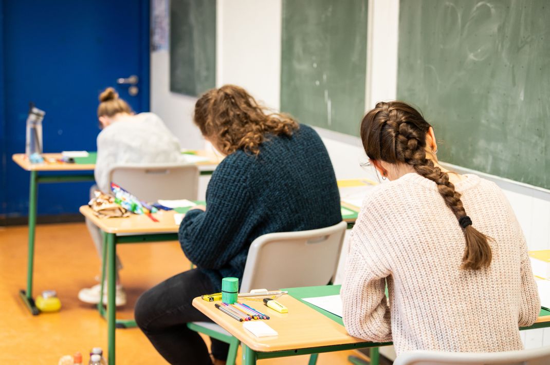 Schülerinnen sitzen bei der Abiturprüfung.