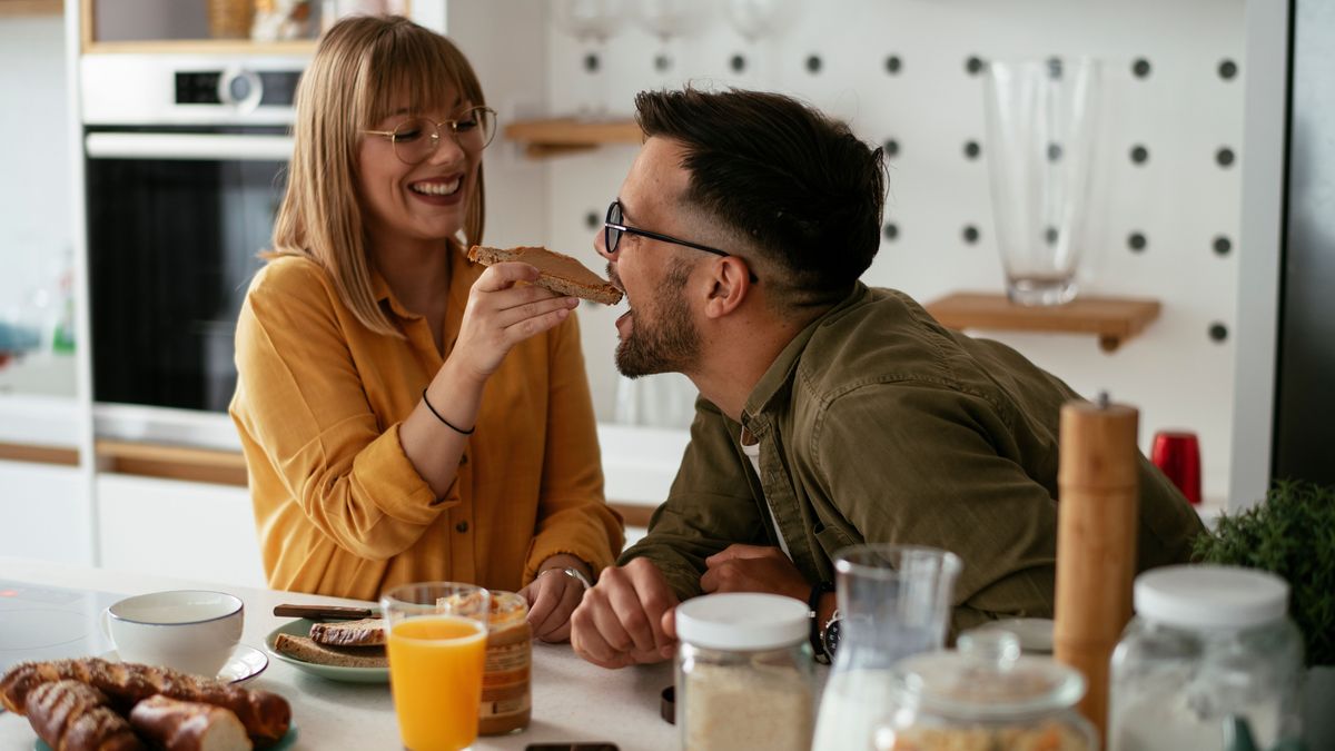 Young couple making sandwich at home. Loving couple enjoying in the kitchen