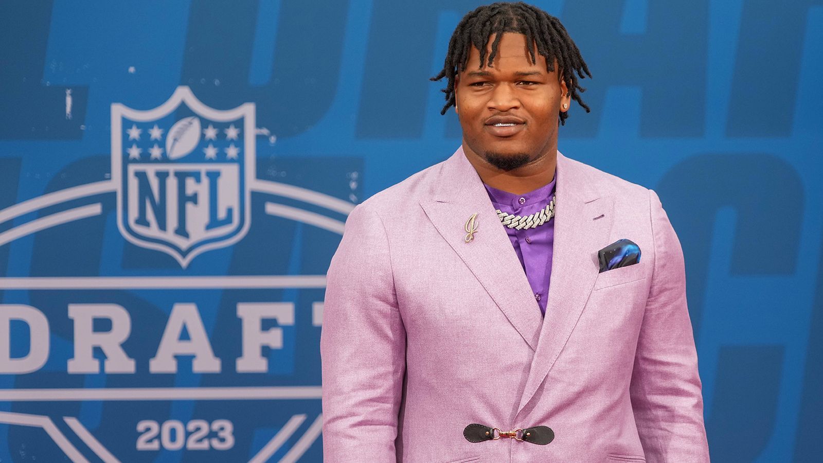 
                <strong>Jalen Carter </strong><br>
                Skandal-Spieler und Eagles-Pick Jalen Carter hielt sich "outfit-technisch" zurück und kombinierte seine Diamant-Kette mit einem rosafarbenen Anzug und einem lila Hemd.
              