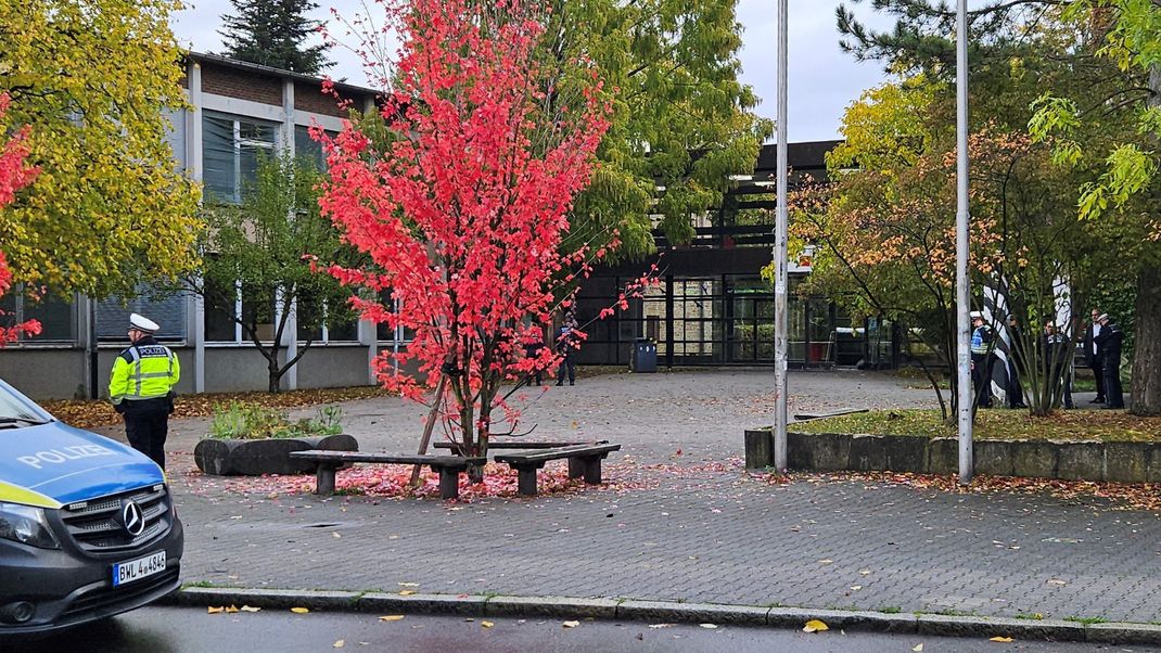 Einsatzkräfte der Polizei stehen vor dem Hegel-Gymnasium im Stadtbezirk Vaihingen. 