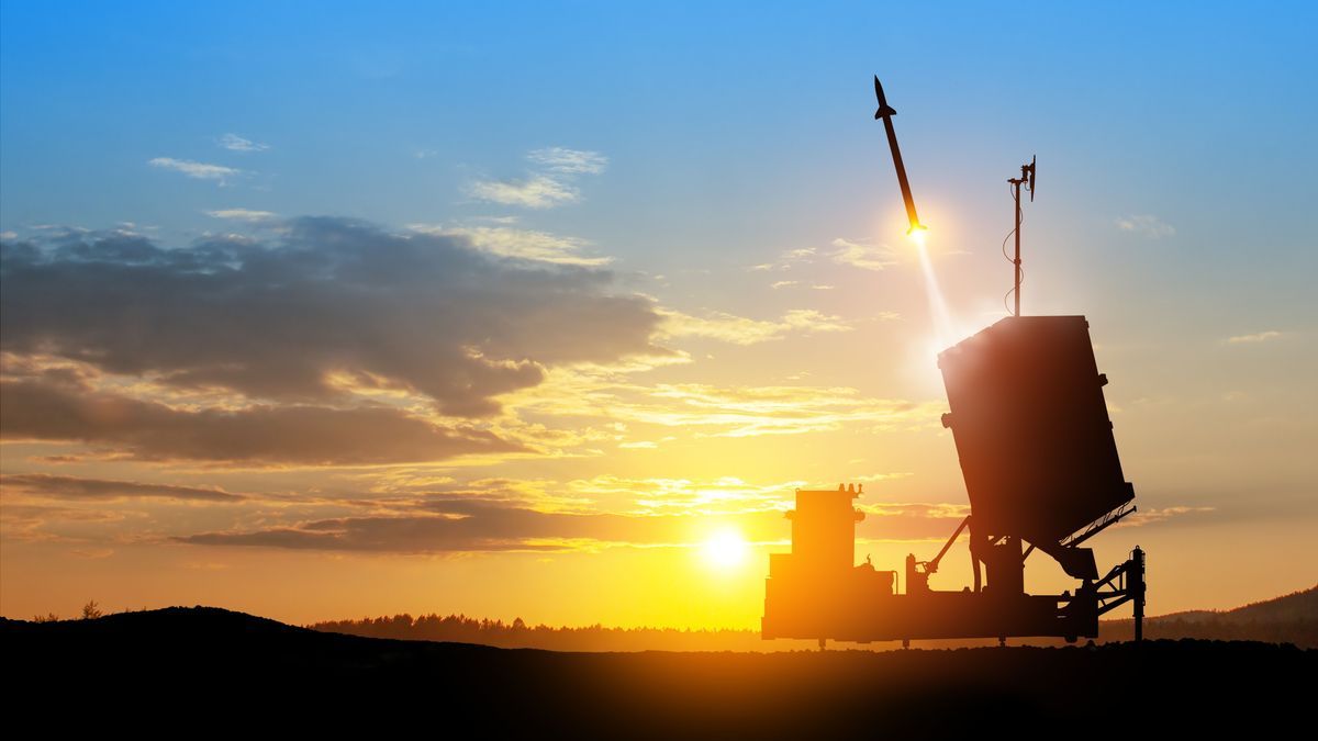 Israel's Iron Dome air defense missile launches. The missiles are aimed at the sky at sunset.