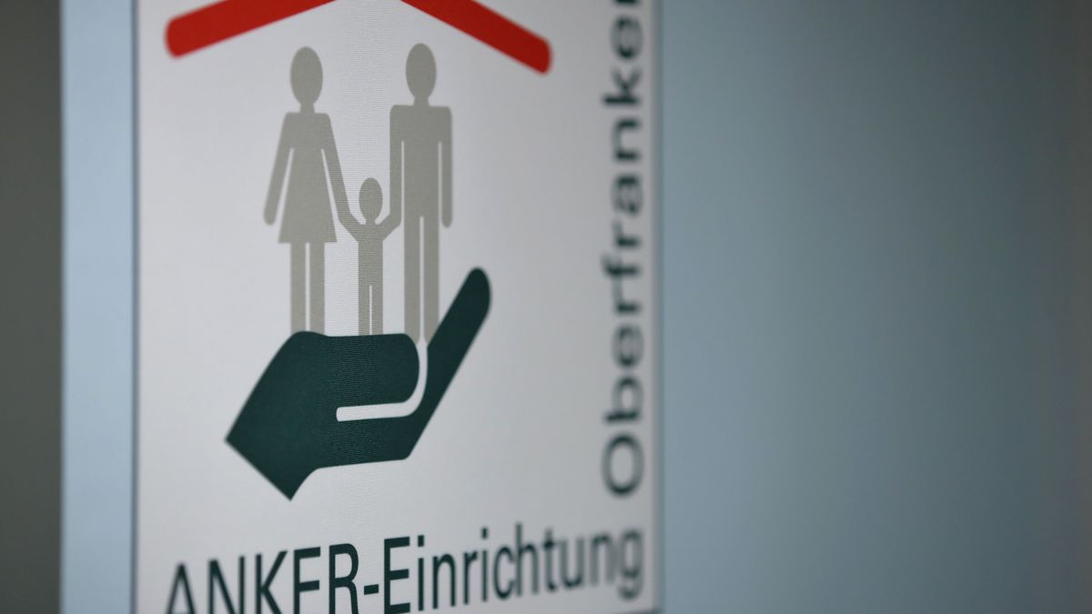 Anker-Einrichtung Oberfranken steht auf einem Banner in den Verwaltungsräumen des Ankerzentrums für Geflüchtete.