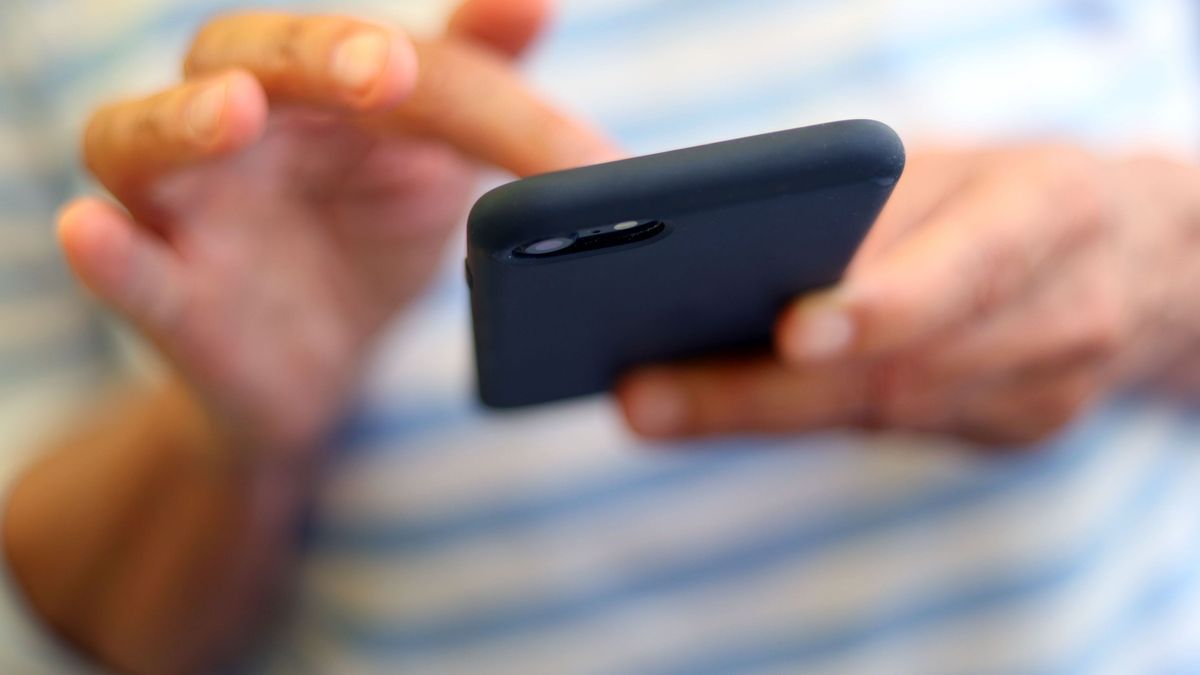 Eine Frau tippt auf einem Smartphone. 