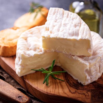 Camembert cheese with rosemary on wooden board