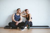 Athlete couple smiling after good workout in gym. Sporty Gym Concept