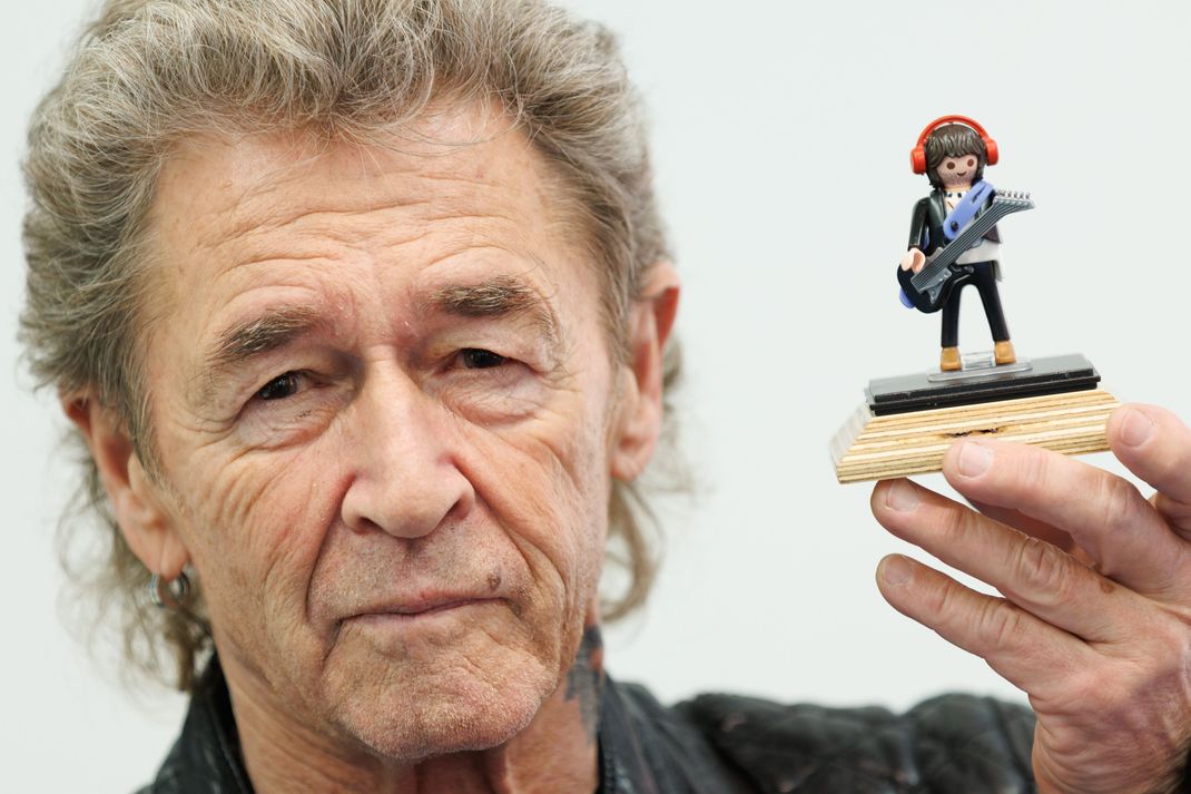 Peter Maffay, Musiker, hält am Rande der Neuheitenschau der Spielwarenmesse am Stand von Playmobil eine Figur mit seinem Konterfei in der Hand. Foto: Daniel Karmann/dpa +++ dpa-Bildfunk +++