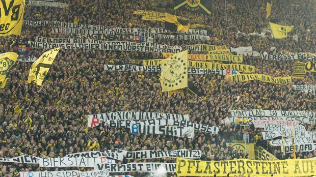 
                <strong>Plakate RB BVB</strong><br>
                Der Protest gegen RB Leipzig hat beim Spitzenspiel in Dortmund eine neue Eskalationsstufe erreicht. Neben Ausschreitungen im Vorfeld des Spiels, als Leipziger Anhänger und Polizisten angegriffen wurden, zielten die BVB-Fans mit Plakaten in der Stadt und auch innerhalb des Stadions unter die Gürtellinie. "Pflastersteine auf die Bullen!" und "Bullen schlachten" hieß es unter anderen. Auch ein geschmackloses Plakat an RB-Sportchef Ralf Rangnick gab es: "Burnout Ralle, häng dich auf!" Hintergrund: Rangnick musste seine Karriere im September 2011 als damaliger Schalke-Coach unterbrechen, weil er an einer Burnout-Erkrankung litt. Im Juli 2012 kam er dann als Sportdirektor von RB Salzburg und RB Leipzig zurück in den Profi-Fußball. Der DFB wird wegen der Entgleisungen innerhalb des Stadions Ermittlungen aufnehmen. Es war allerdings nicht das erste Mal, dass gegen RB protestiert wurde.
              