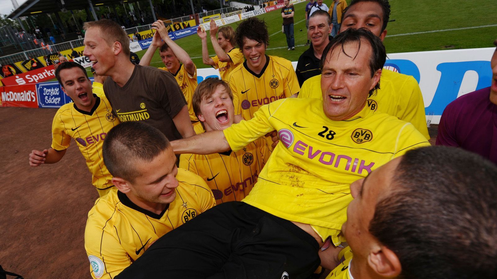 
                <strong>Theo Schneider (vereinslos)</strong><br>
                Fünf Jahre und fast zehn Monate war Theo Schneider Trainer der zweiten Mannschaft von Dortmund. Kein anderer Trainer hat so viele Spiele mit der Zweiten von Dortmund absolviert wie er – nämlich 203. Nur Lothar Huber kommt auf eine kanpp längere Amtszeit(1986-1992), allerdings mit nur 129 Spielen unter seiner Führung. Zuletzt war Schneider Leiter der Nachwuchsabteilung des ungarischen Erstligisten Ferencváros Budapest.
              