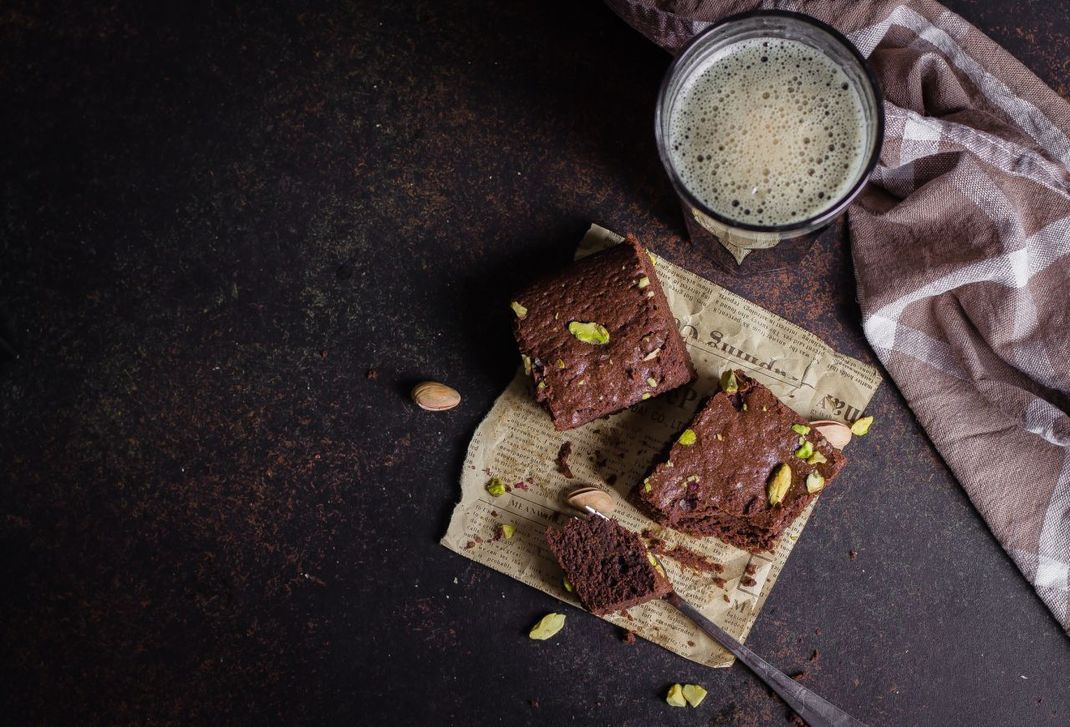 Noch einen draufsetzen: Wer möchte, kann die Bier-Brownies mit Pistazien-Kernen dekorieren oder mit einer Karamell-Glasur überziehen.