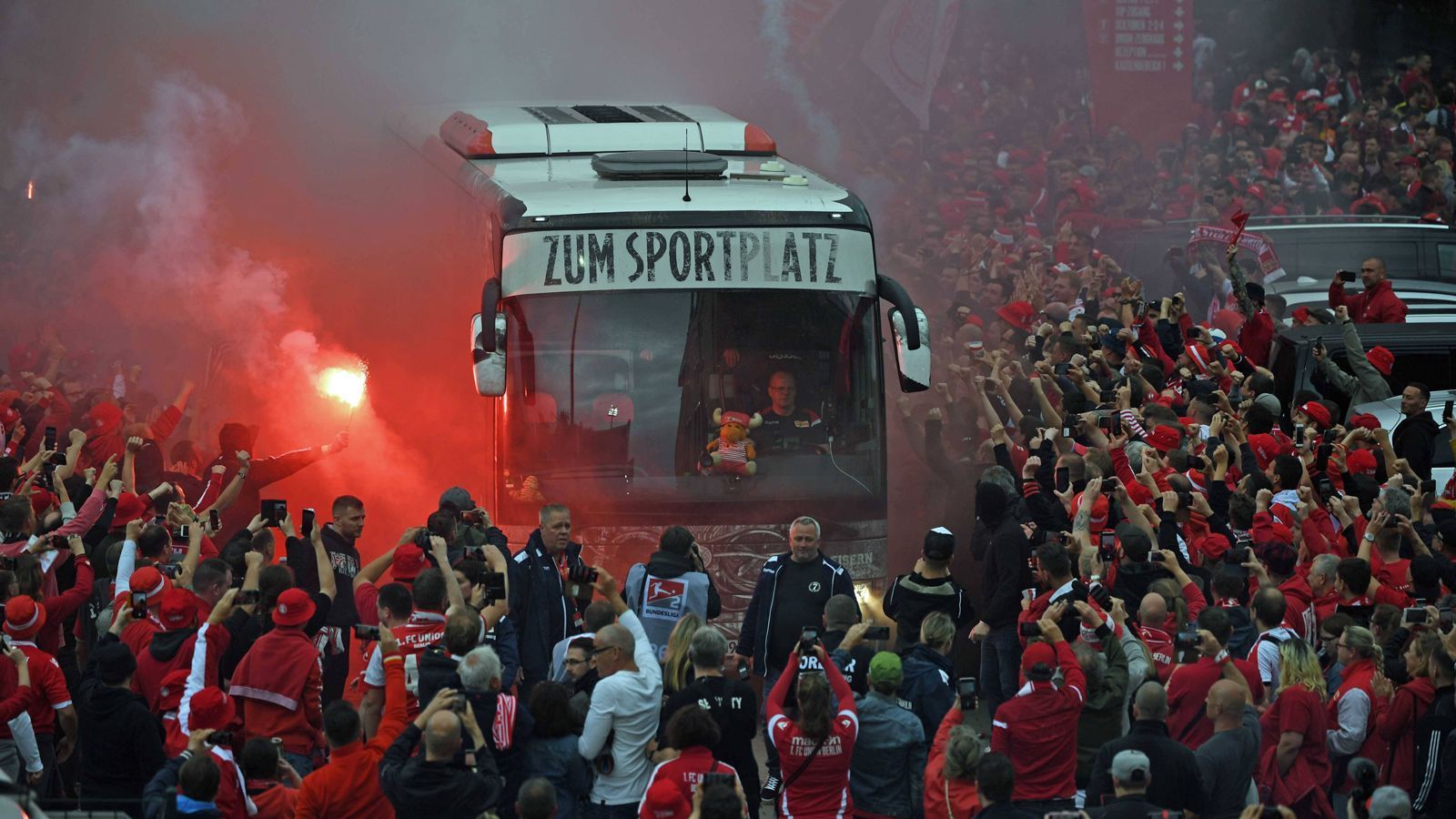 
                <strong>Unions Mannschaftsbus wird von den Massen flankiert</strong><br>
                Die Fans der "Eisernen" heizten ihrer Mannschaft bereits auf dem Weg zur Alten Försterei gehörig ein.
              