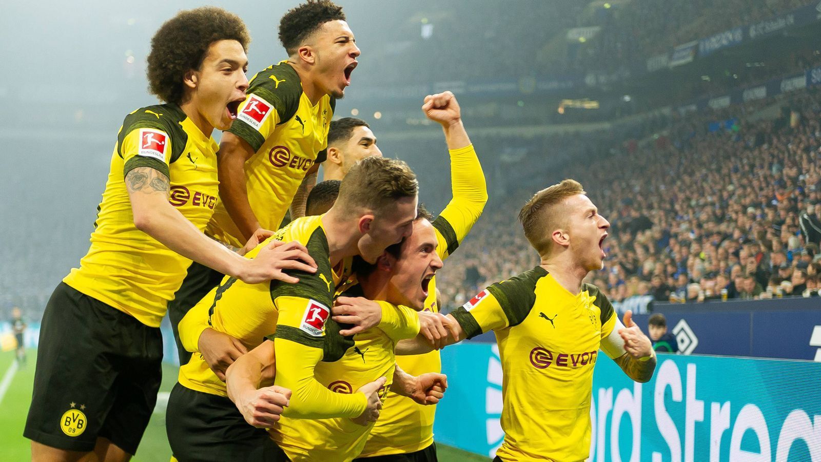 
                <strong>Tor-Vielfalt: 16 verschiedene BVB-Torschützen</strong><br>
                Borussia Dortmund setzt in der Bundesliga nicht nur den Siegeszug unbeirrt fort und ist weiterhin ungeschlagen, der Tabellenführer ist auch weiter auf Rekordjagd. Die neueste Bestmarke gab es beim 2:1-Sieg im Derby auf Schalke: Nach 14 Spieltagen haben 16 verschiedene Spieler für den BVB getroffen – Rekord! Für den BVB trafen Paco Alcacer (10 Tore), Marco Reus (9), Jadon Sancho (5), Jacob Bruun Larsen (2), Christian Pulisic, Marius Wolf, Maximilian Philipp, Mahmoud Dahoud, Mario Götze, Julian Weigl, Axel Witsel, Achraf Hakimi, Abdou Diallo, Manuel Akanji, Lukasz Piszczek (je 1) sowie seit dem Derby nun auch Thomas Delaney, der zum zwischenzeitlichen 1:0 traf. (Quelle: Sky)
              