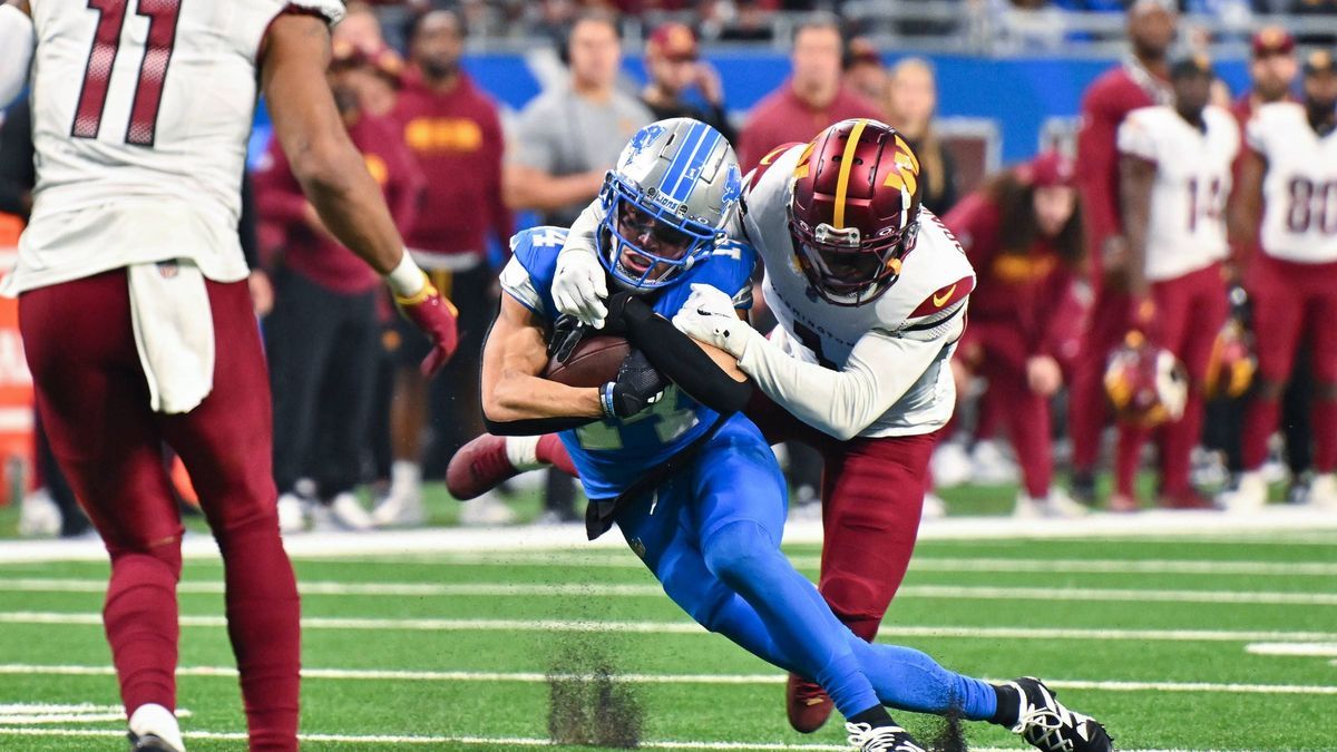 DETROIT, MI - JANUARY 18: Detroit Lions wide receiver Amon-Ra St. Brown (14) makes a catch and is tackled during the NFC Divisional Playoff game between the Detroit Lions and the Washington Command...