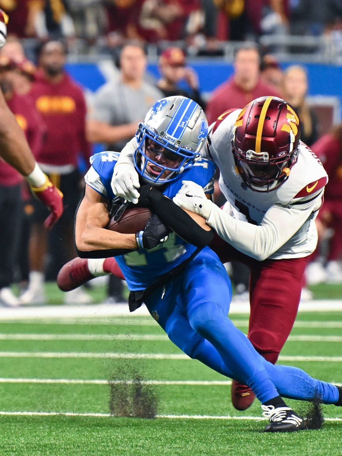 DETROIT, MI - JANUARY 18: Detroit Lions wide receiver Amon-Ra St. Brown (14) makes a catch and is tackled during the NFC Divisional Playoff game between the Detroit Lions and the Washington Command...