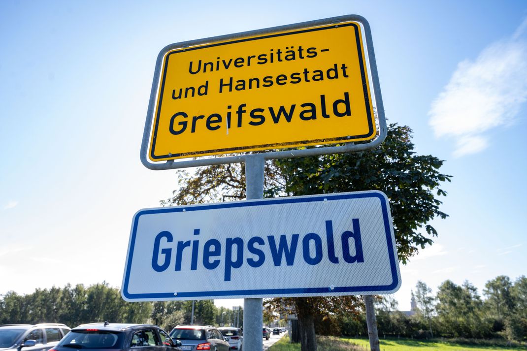 ARCHIV - 21.09.2023, Mecklenburg-Vorpommern, Greifswald: Das Ortsschild der Stadt Greifswald ist ebenso mit dem plattdeutschen Namen versehen. Eine Straftat in Greifswald sprengt die menschliche Vorstellungskraft.(zu dpa "Polizei findet in Greifswalder Wohnung zerstückelte Leiche") Foto: Stefan Sauer/dpa +++ dpa-Bildfunk +++