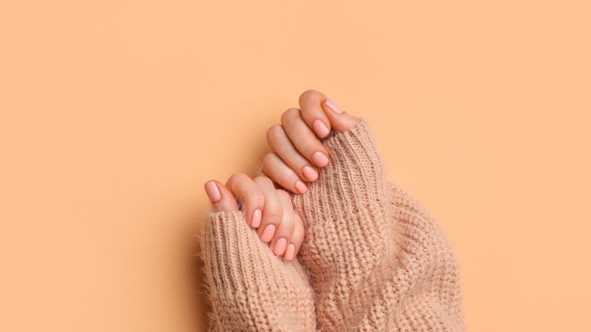 Hands with beautiful manicure on color background