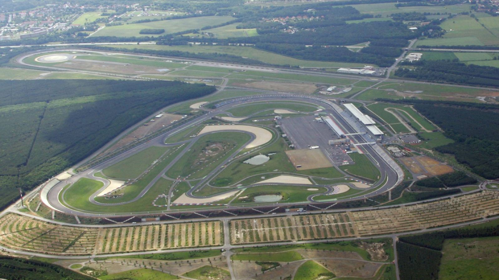 
                <strong>Lausitzring (23.07. bis 25.07.) - Das Wohnzimmer der DTM</strong><br>
                Im Vergleich zu Monza oder auch dem Nürburgring ist der Lausitzring (4,575 km) ein Rookie im Kreis der besten europäischen Rennstrecken. Eine der modernsten ist die Anlage allemal. Schließlich wird auf dem EuroSpeedway Lausitz, wie der Kurs auch genannt wird, erst seit dem Jahr 2000 gestartet - vor bis zu 120.000 Zuschauern. Entsprechend modern präsentiert sich die Infrastruktur mit mächtiger Haupttribüne, weitläufiger Boxengasse und großzügig umgesetztem Fahrerlager. In Bezug auf die DTM aber ist der Lausitzring schon ein alter Hase. Im September 2019 fand hier das 500. DTM-Rennen statt!
              