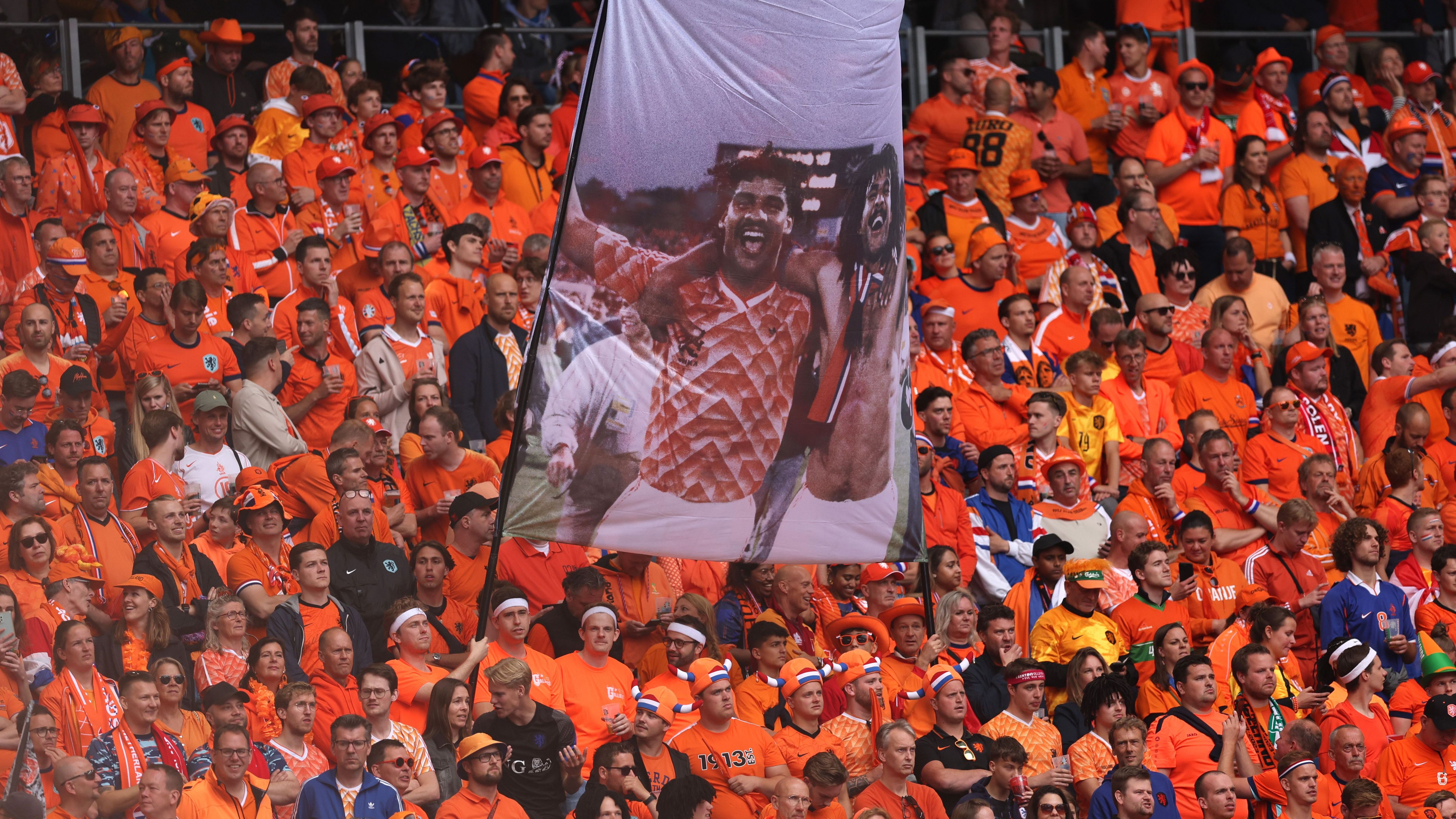 <strong>Oranje-Fans erinnern an alte Glanzzeiten</strong><br>Im Stadion erinnern die Oranje-Fans an zwei ganz Große. Frank Rijkaard und Ruud Gullit wurden 1988 Europameister. Auch damals fand das Turnier in Deutschland statt. Übrigens: Zwei Jahre später sorgte Rijkaard (li.) mit seiner Spuck-Attacke gegen Rudi Völler im WM-Achtelfinale für Furore.&nbsp;