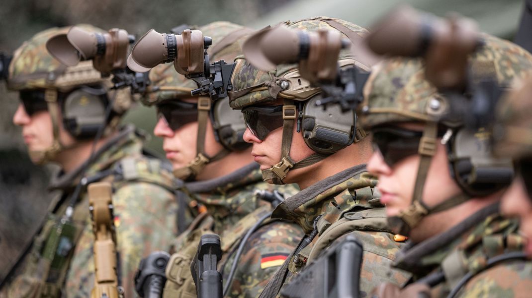 Bewaffnete Grenadiere im Ausrüstungszustand stehen auf einem  Bundeswehrgelände.