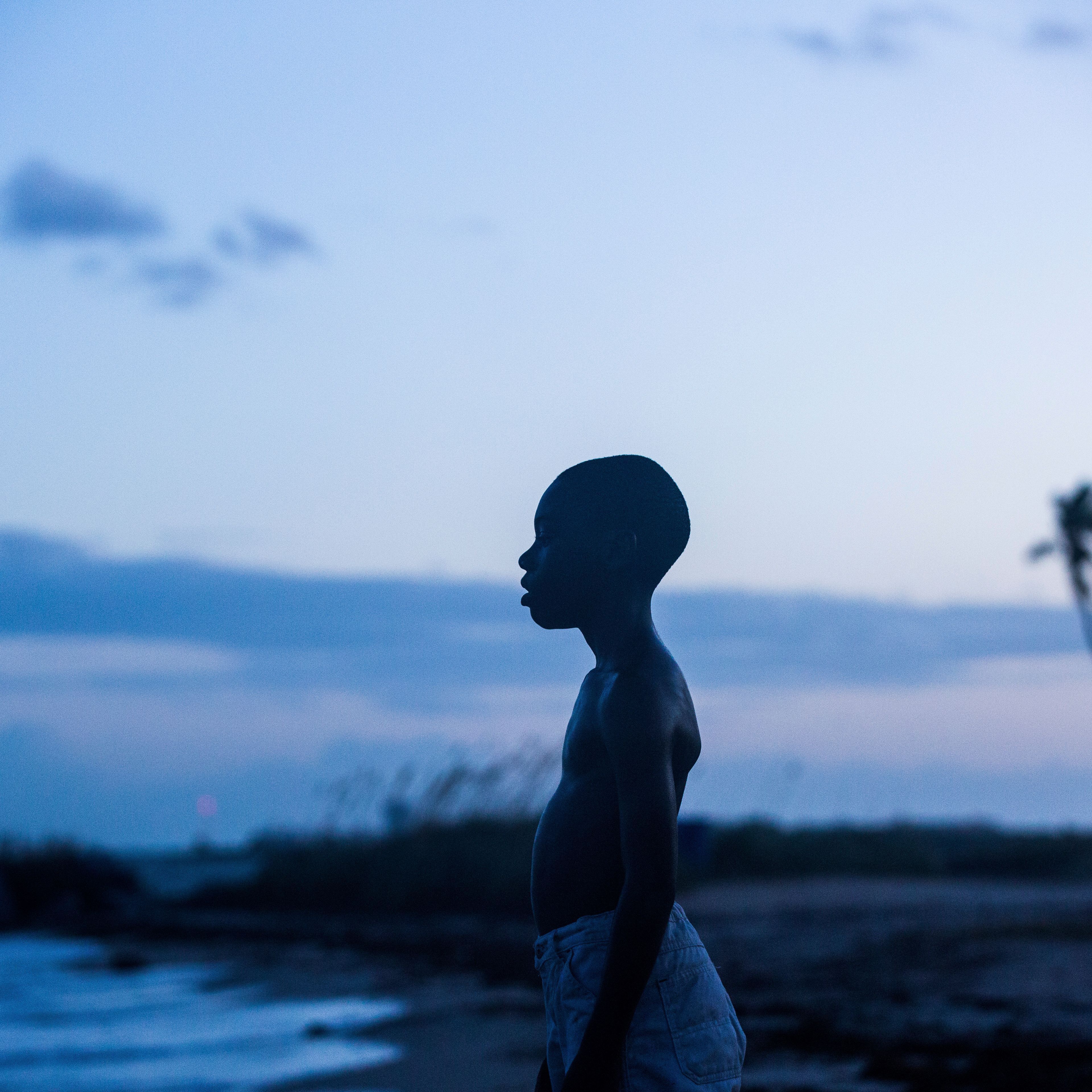 Szene aus "Moonlight", Junge steht am Wasser, die Sonne ist fast untergegangen.