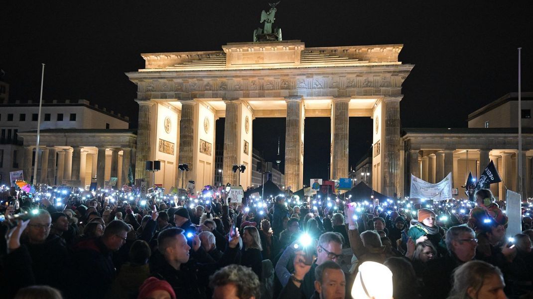 25. Januar 2025, Berlin: Menschen halten Lichter auf der Demonstration "Lichtermeer gegen den Rechtsruck" am Brandenburger Tor hoch.