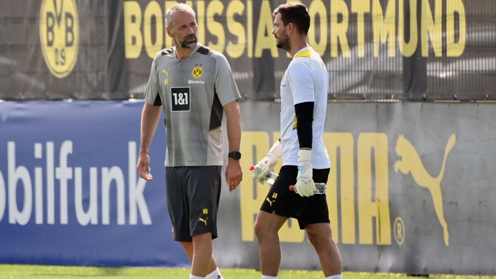 
                <strong>Was wird aus Keeper Bürki?</strong><br>
                Für Rose war es zum Trainingsauftakt wichtig, Einzelgespräche mit seinen Akteuren zu führen - hier eben mit Torhüter Roman Bürki (re.). Die Zukunft des Schweizers ist trotz Vertrages bis 2023 ungewiss. Mit Gregor Kobel hat Dortmund bereits eine designierte Nummer 1 für die Saison 2021/22 verpflichtet und um Bürki gab es zuletzt immer wieder Abwanderungsgerüchte. 
              