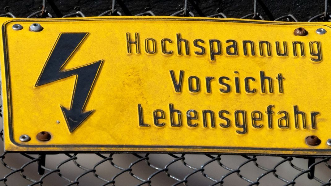 Ein Schild mit der Aufschrift "Hochspannung Vorsicht Lebensgefahr" warnt.