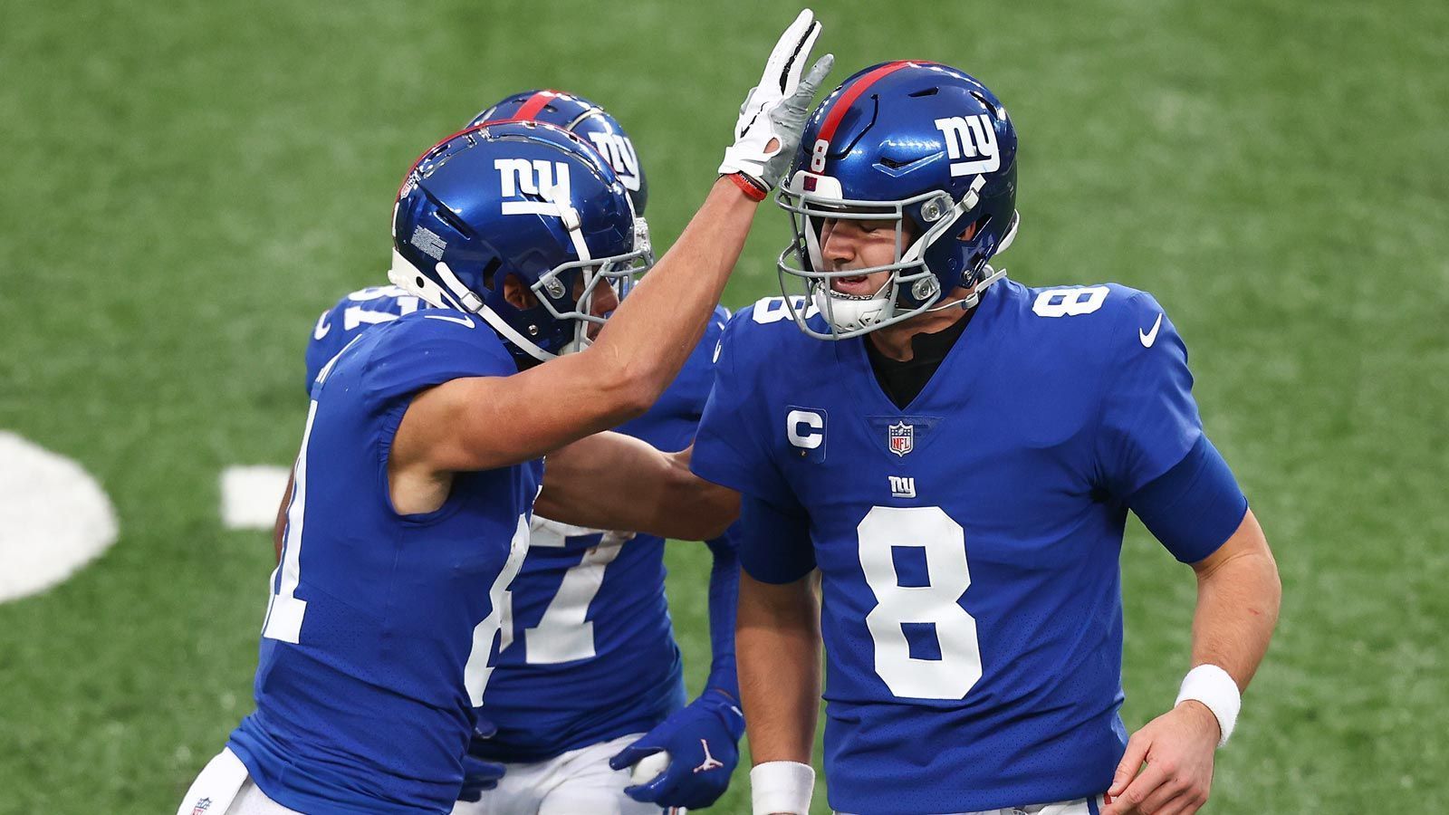 
                <strong>Platz 25 - New York Giants</strong><br>
                Mit Receiver Kadarius Toney stellen die "G-Men" Quarterback Daniel Jones (im Bild, rechts) eine weitere Offensiv-Waffe zur Verfügung und sichern sich dabei sogar einen zukünftigen Erstrunden-Pick der Bears. Vier der folgenden fünf Picks (darunter der vielversprechende Linebacker Azeez Ojulari) werden sich in der Defense einsortieren und stärken eine bereits schlagkräftige Einheit. Ähnlich wie die Panthers ist auch die Mannschaft von Head Coach Joe Judge auf dem richtigen Weg, doch auch in New York hängt alles von der Entwicklung des Quarterbacks ab.
              