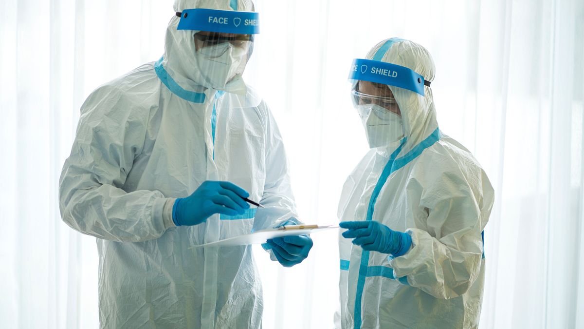 Asian doctor holding checking coronavirus or covid-19 infected patient name list sheet in quarantine area in hospital. Corona virus, Covid 19 virus outbreak, medical mask or virus outbreak concept