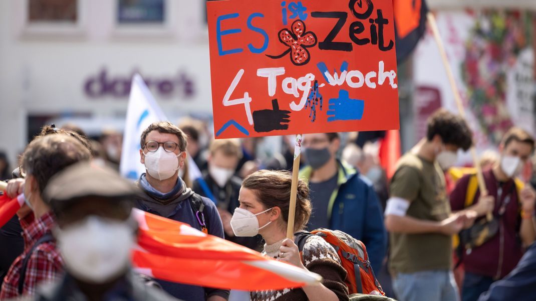 Eine Person hält ein Schild zur Vier-Tage-Woche auf einer DGB-Kundgebung.