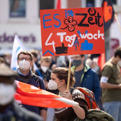 Eine Person hält ein Schild zur Vier-Tage-Woche auf einer DGB-Kundgebung.