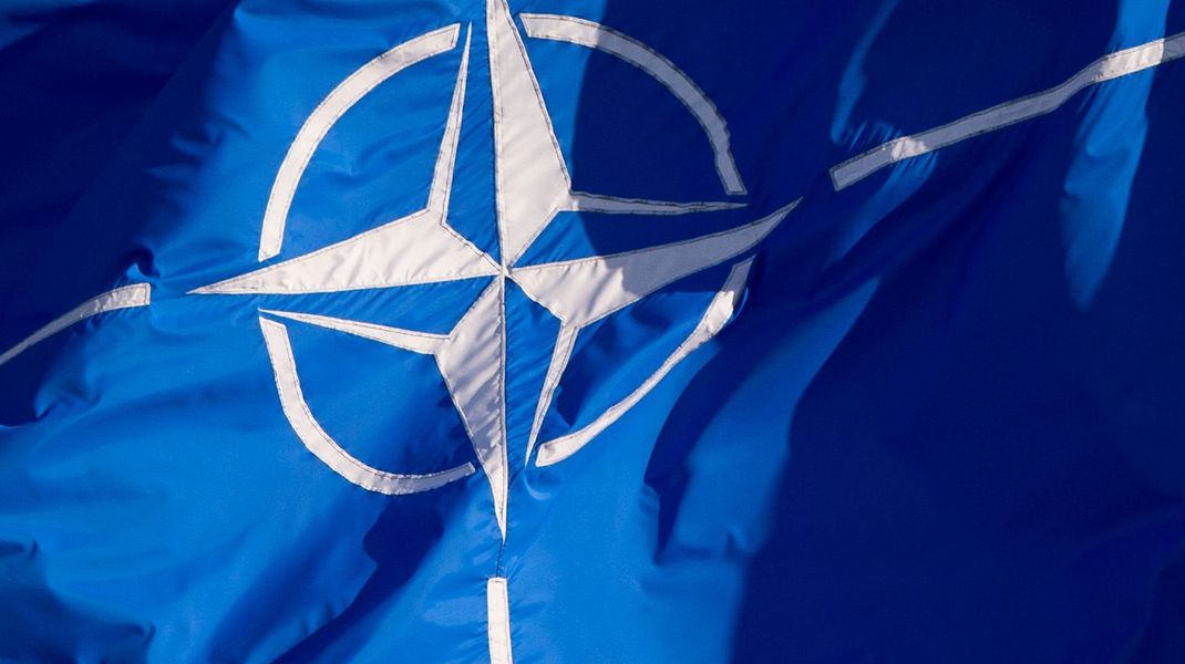 Eine Flagge der NATO weht beim Außenministertreffen. Das Militärbündnis wird bald Zuwachs bekommen.