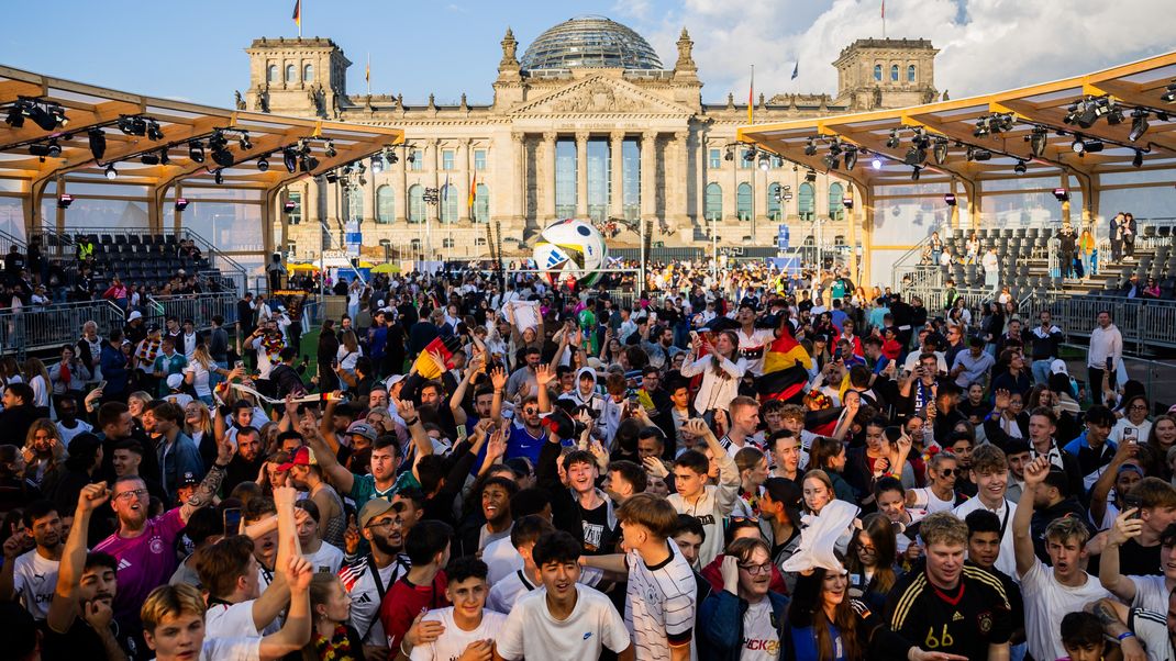 Deutschland-Fans feiern beim Public Viewing in der Fanzone am Reichstagsgebäude bei schönstem Wetter. Bleibt es so?