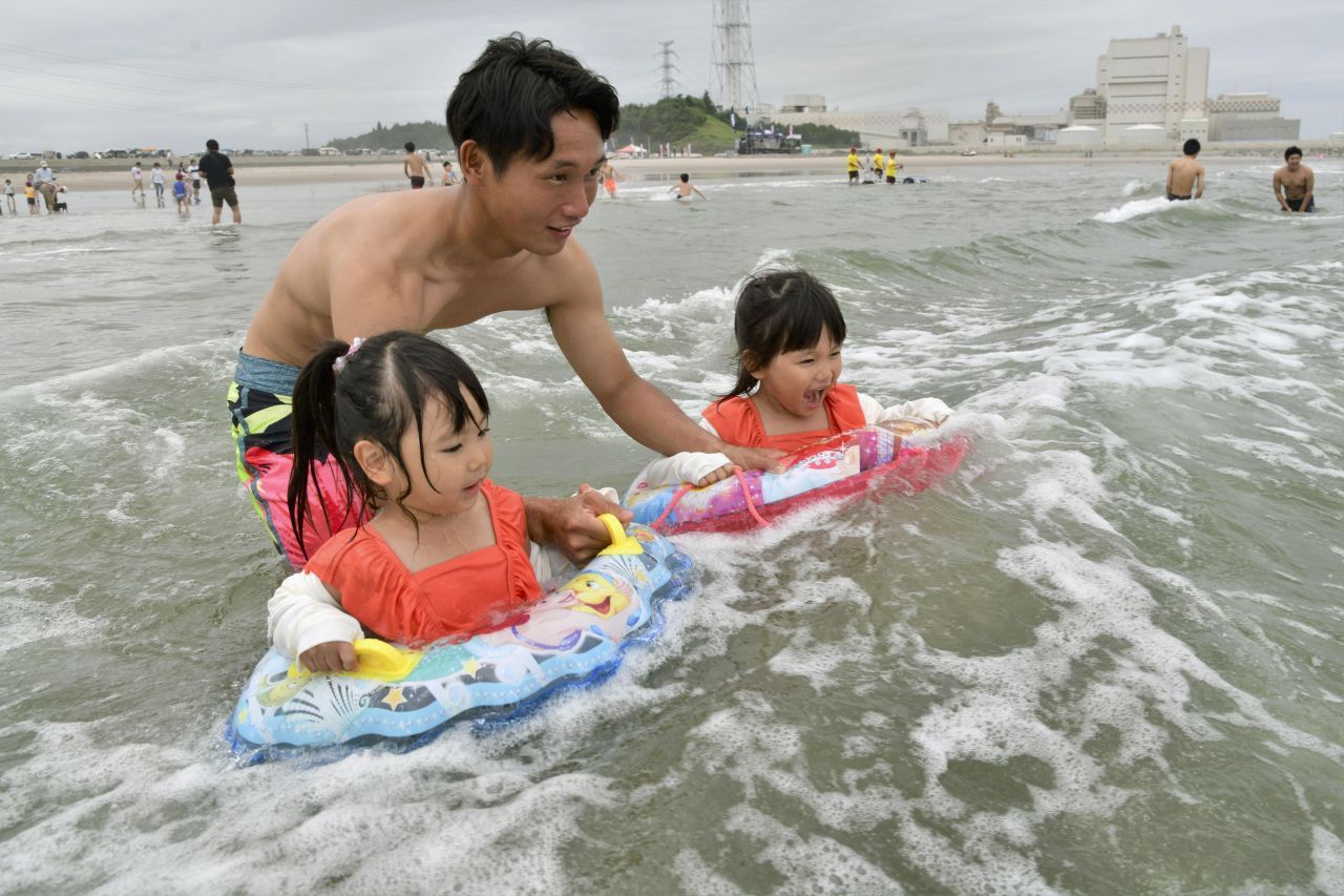 Dieser Familienvater badet mit seinen Kindern am Strand der Stadt Minamisoma - 25 Kilometer vom Unglücks- Atomkraftwerk Fuskushima Daiichi entfernt. Die Behörden erklärten Strände und Wasser im Juli 2019 wieder für sicher. 