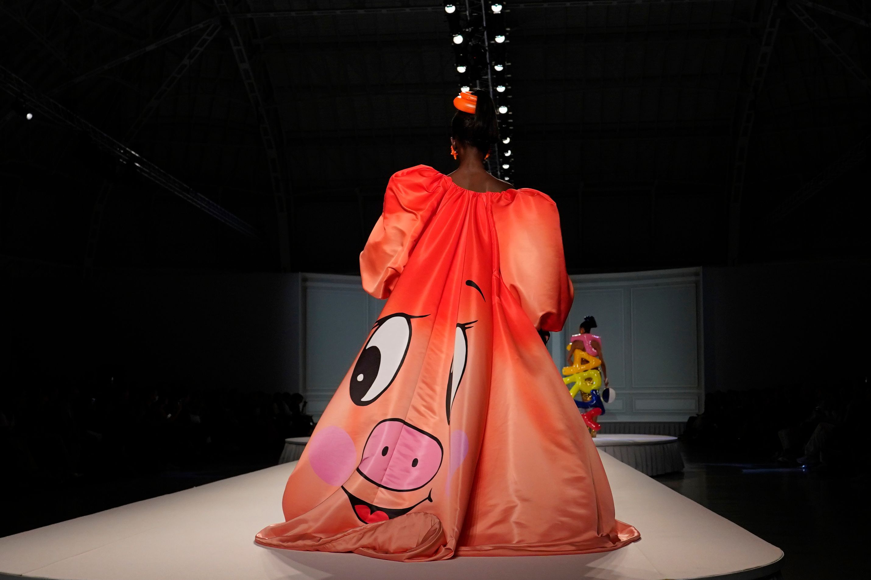 Ein Model trug eine Kreation mit dem Motiv eines glücklichen Schweinchens von der Moschino women's Spring Summer 2023 Kollektion.