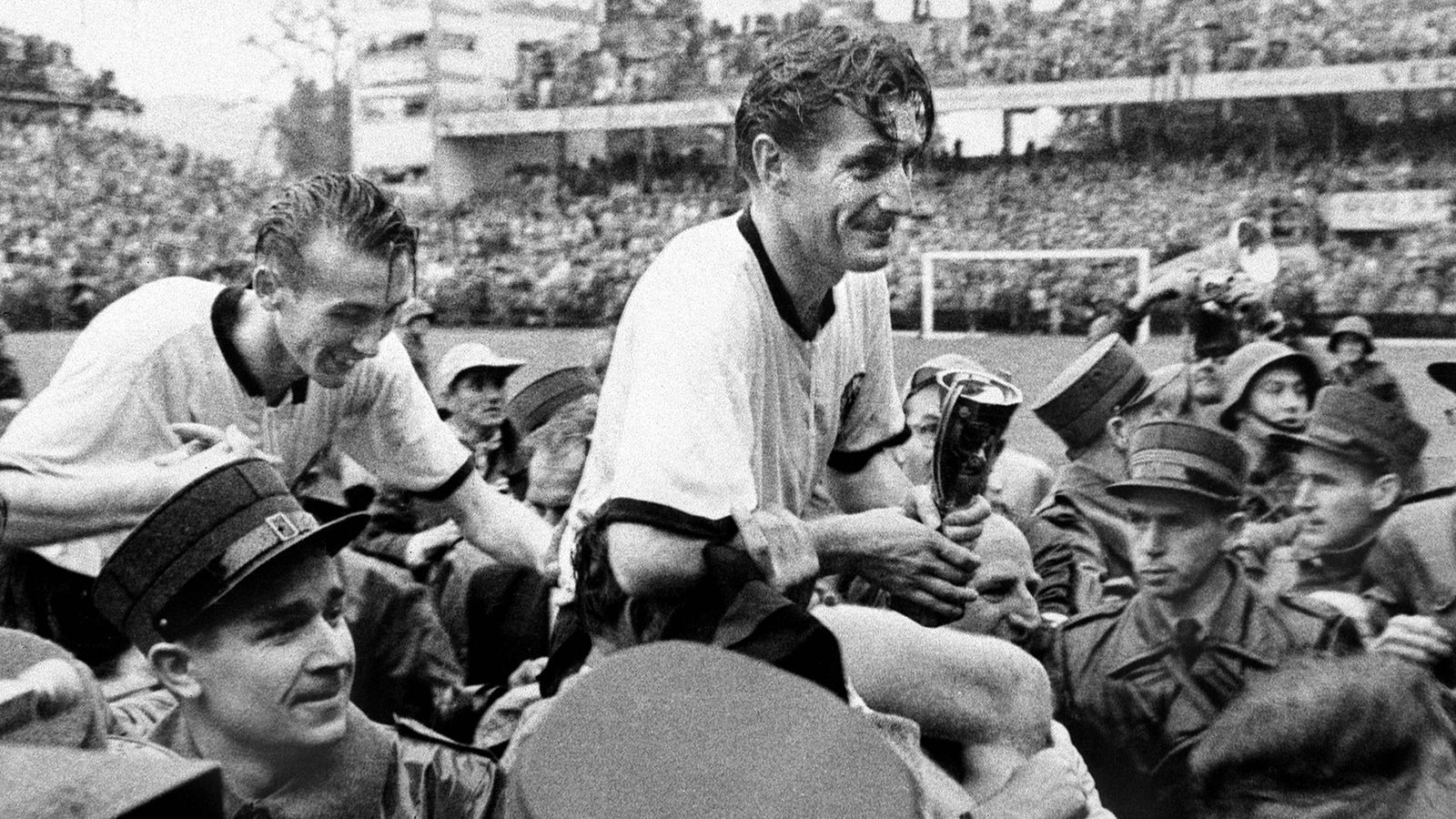 
                <strong>WM 1954 - Deutschland</strong><br>
                Mit Pokal in der Hand wird Deutschlands Kapitän Fritz Walter durch das Stadion getragen. Deutschland gewinnt in einem packenden Endspiel gegen den haushohen Favoriten aus Ungarn mit 3:2 und sorgt somit für "Das Wunder von Bern". Gleichzeitig war die WM 1954 auch die erste, welche die offizielle Bezeichnung Fußball-Weltmeisterschaft tragen durfte. 
              