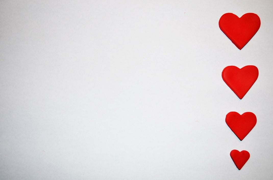 Rote Herzen auf weißem Papier - ein schönes Motiv für die Vorderseite deiner Karte zum Tag der Liebe.
