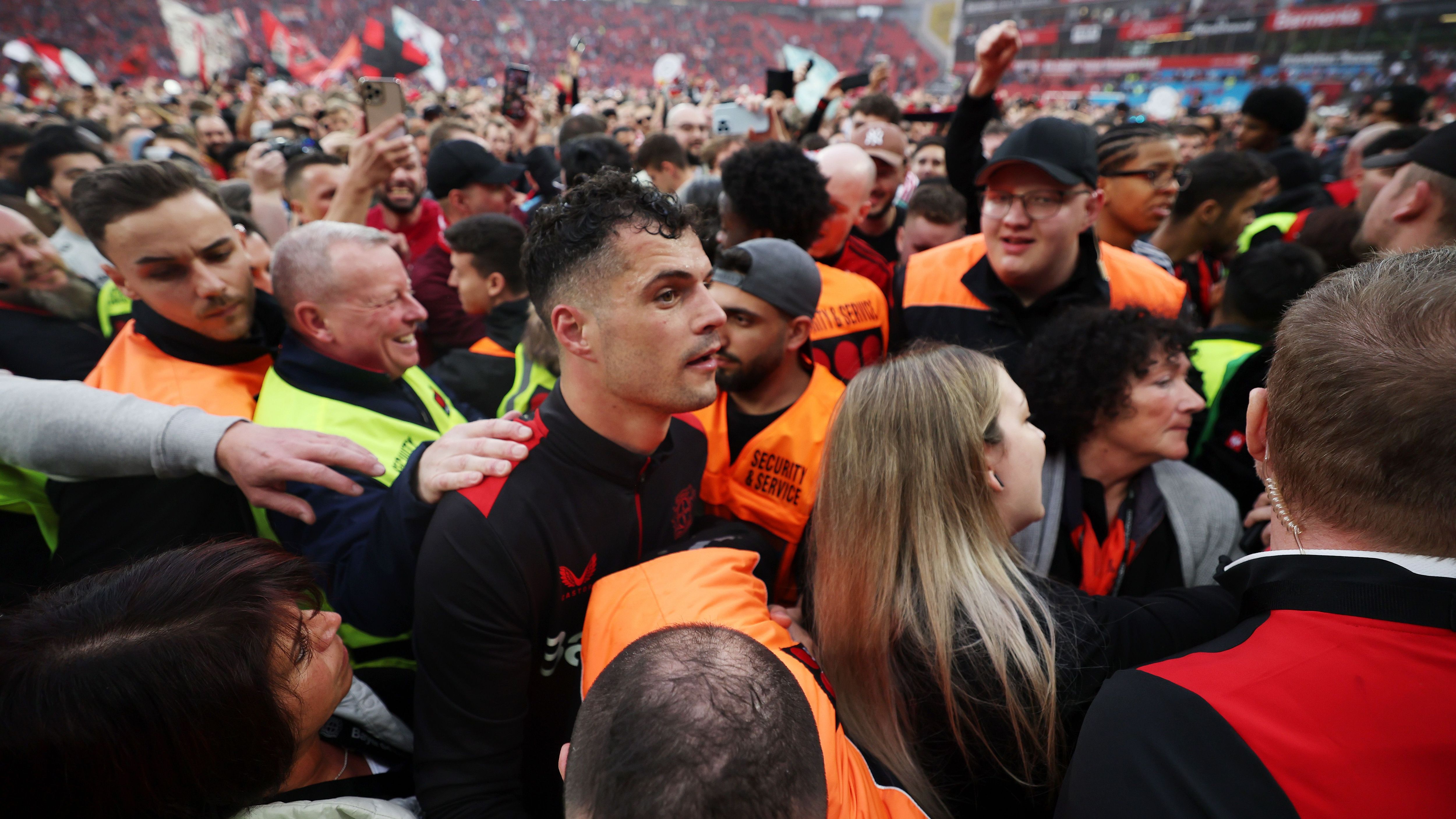 <strong>Bayer Leverkusen: Die besten Bilder der Meisterfeier</strong><br>Auch für die Spieler gibt es kein Entrinnen. Sie werden - wie hier Granit Xhaka - einfach umringt. Allerdings kümmern sich Ordner darum, dass die Helden heil bleiben.