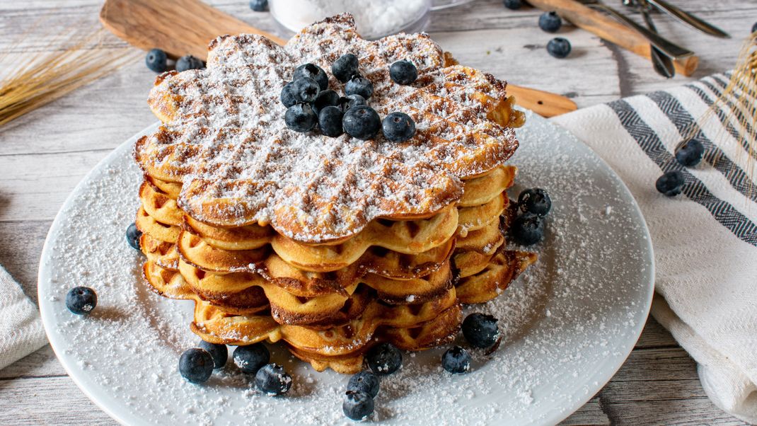 Ob ganz traditionell mit Puderzucker und Apfelmus, oder amerikanisch mit Speck und Ahornsirup - Waffeln schmecken in allen Formen und Farben.