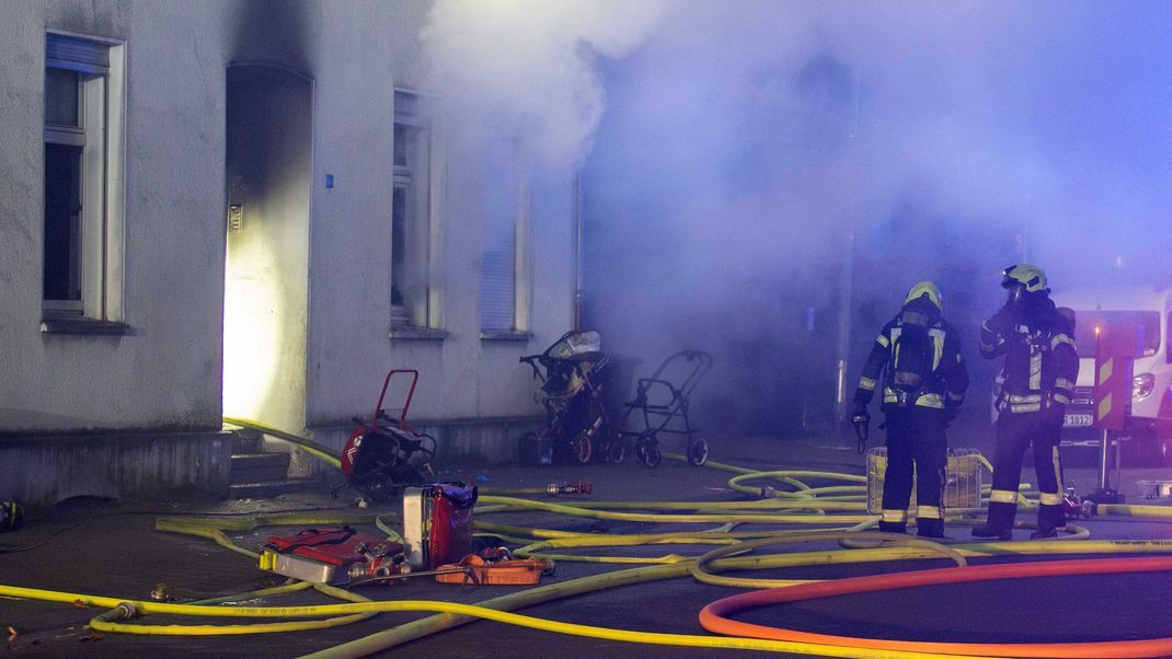 Gelsenkirchen: Einsatzkräfte der Feuerwehr löschen den Brand in einem Mehrfamilienhaus. 