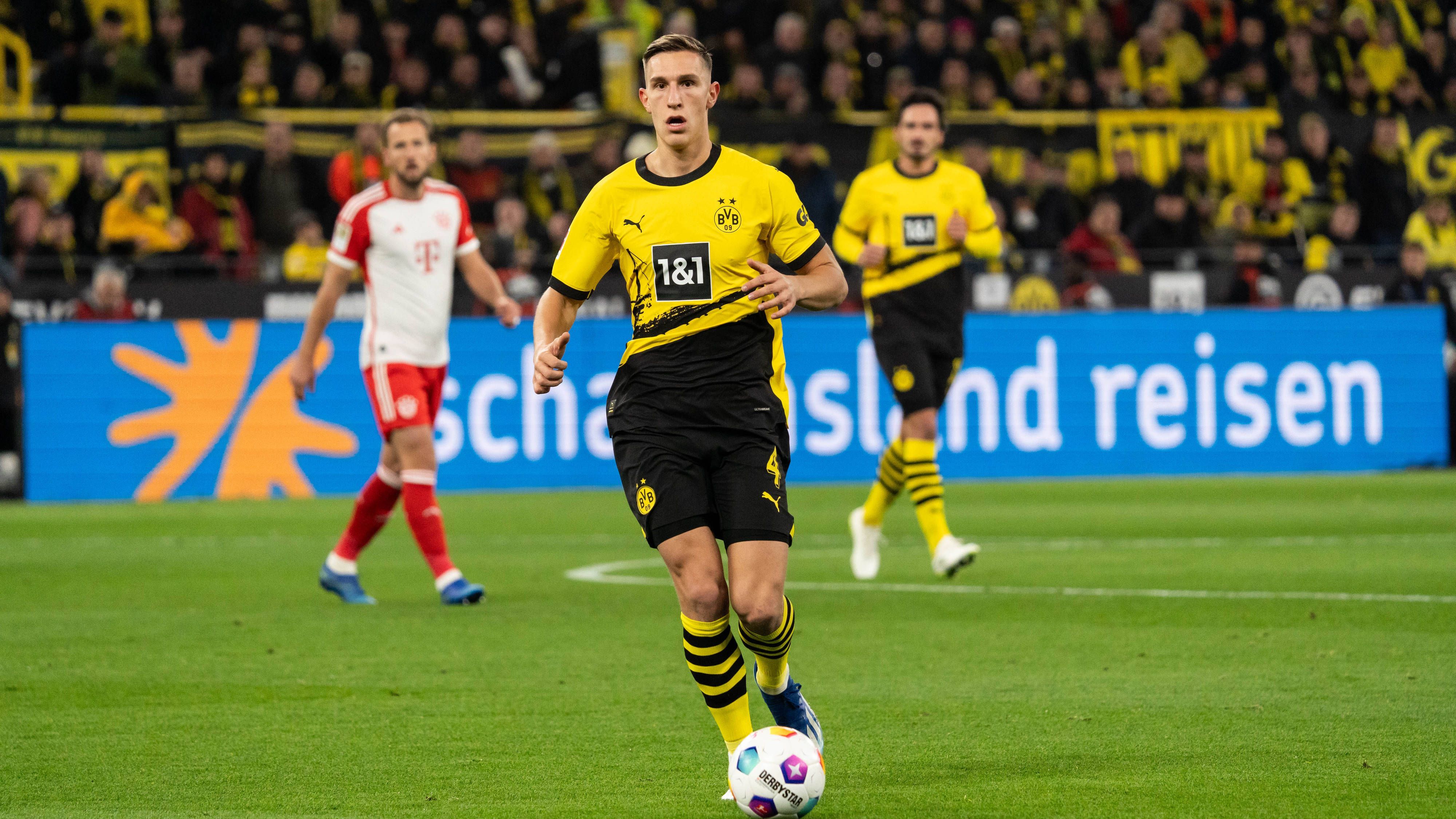 <strong>Nico Schlotterbeck<br></strong>Vor dem Spielbeginn ist Nico Schlotterbeck im Kabinengang während der BVB-Hymne noch gut gelaunt und singt mit. Lässt beim 0:1 Upamecano einfach ziehen. Nach vorne kann sich Schlotterbeck kaum einmal einschalten, lediglich ein abgeblockter Schussversuch in der 53. Minute springt heraus. <strong><em>ran</em>-Note: 5</strong>