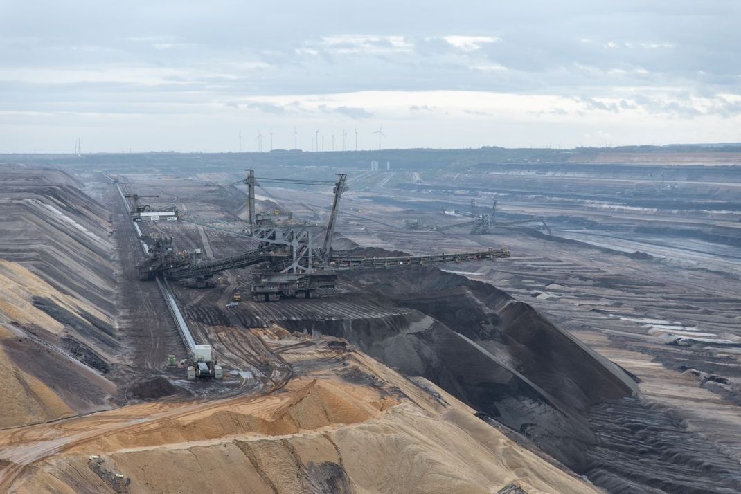 Riesiger Bagger tragen wie hier beim Braunkohletagebau Garzweiler das Material ab und hinterlassen eine zerstörte Landschaft.