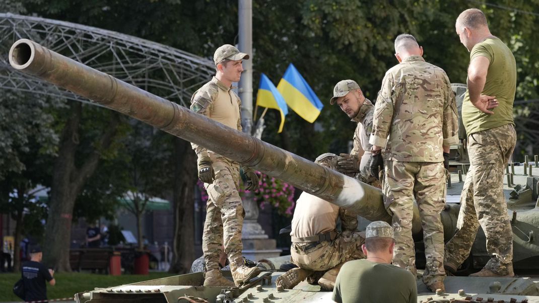 Soldaten bereiten eine Ausstellung mit erbeuteten russischen Panzern auf einer Straße in Kiew vor.