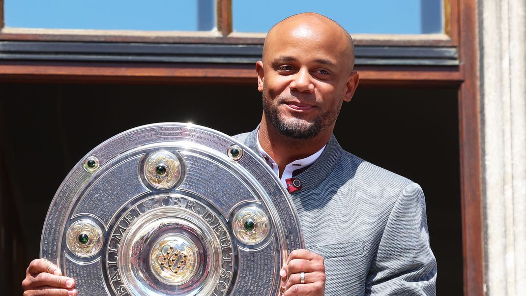 Trainer Vincent Kompany steht mit der Meisterschale auf dem Rathaus-Balkon.