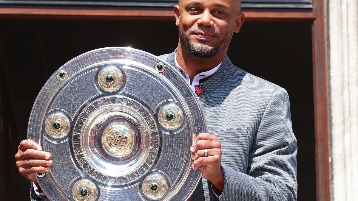 Trainer Vincent Kompany steht mit der Meisterschale auf dem Rathaus-Balkon.