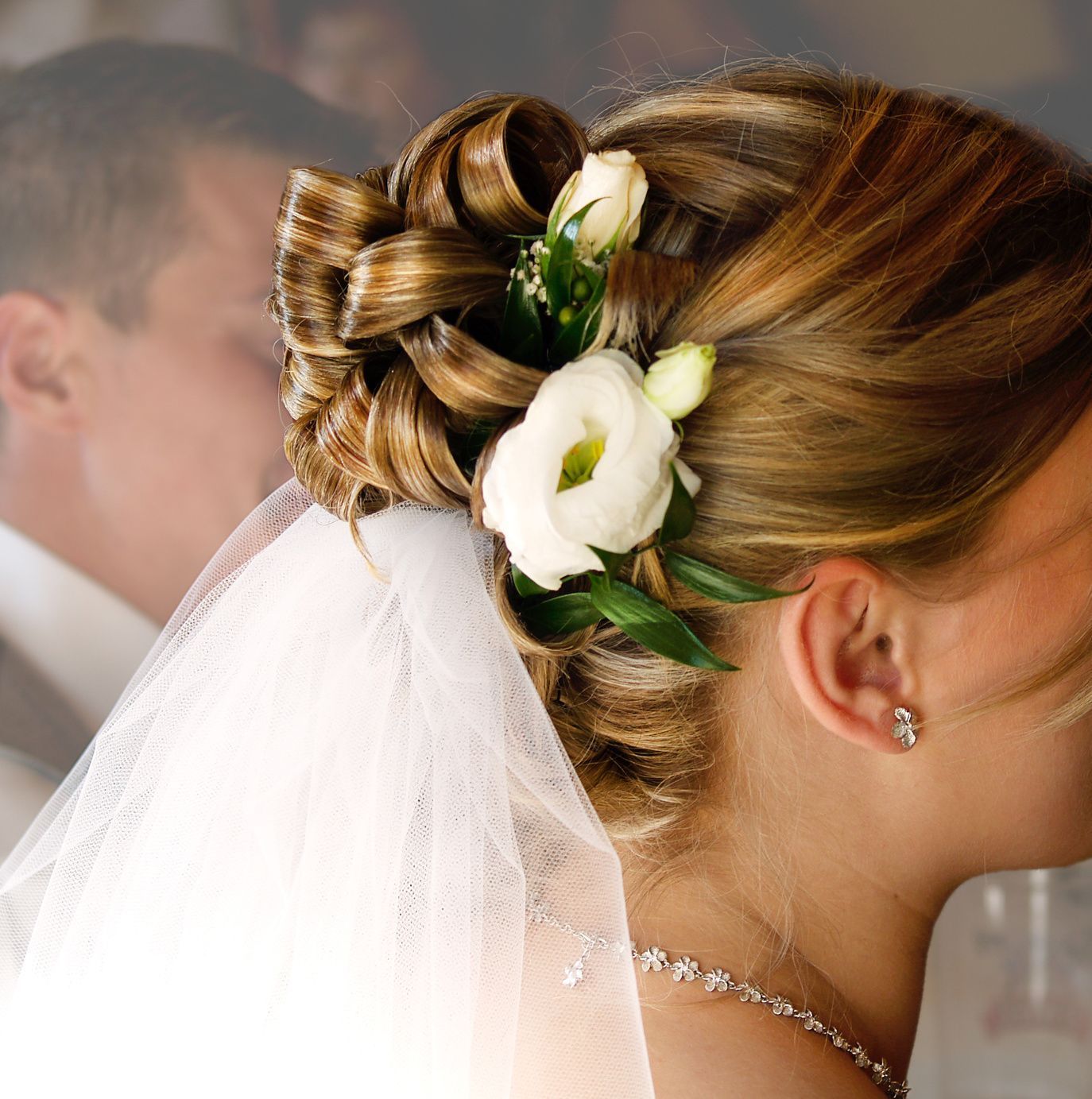 Romantisch und natürlich: Blumen im Haar lockern die Brautfrisur auf.