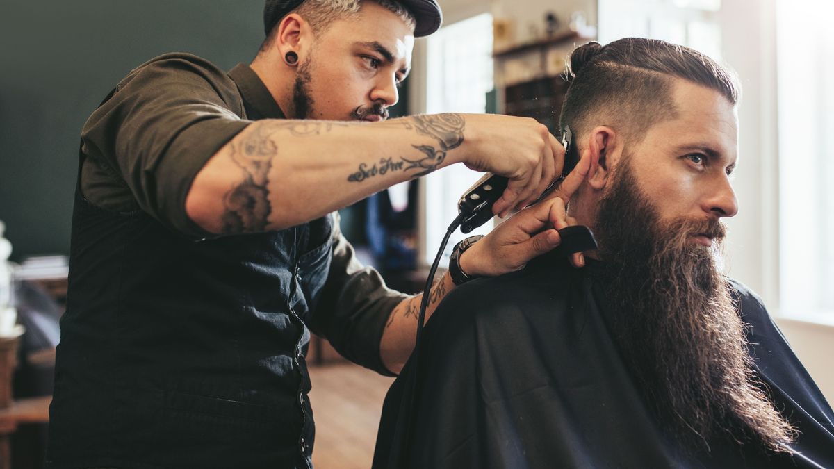 Man getting trendy haircut in barbershop