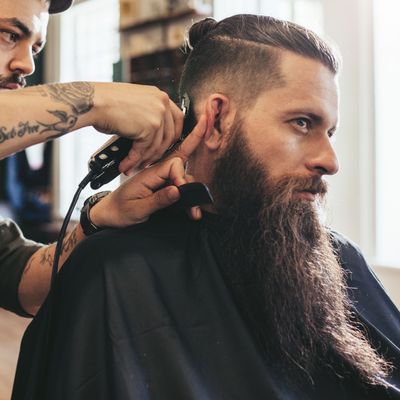 Man getting trendy haircut in barbershop