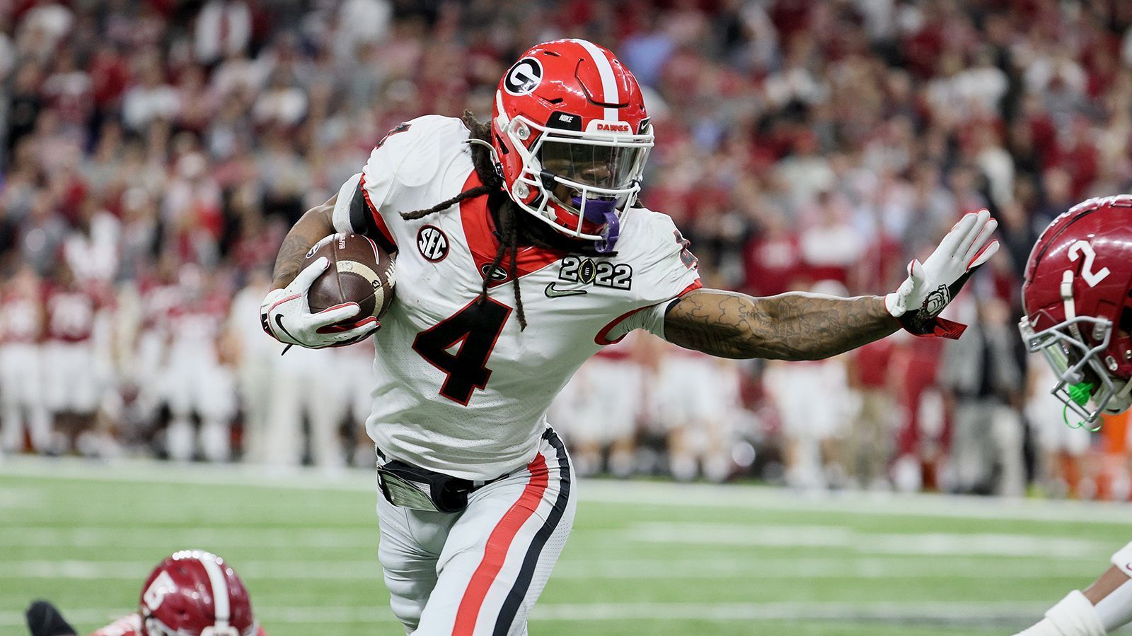 
                <strong>James Cook (Georgia Bulldogs) </strong><br>
                Der kleine Bruder von Vikings-Star Dalvin Cook ähnelt dem NFL-Star nur in manchen Bereichen des Spiels. James Cook bringt eine ähnliche Athletik mit und beweist durchaus die Geschwindigkeit, um Defendern davonzurennen. Allerdings ist er schmaler gebaut als sein großer Bruder und kommt viel über seine Agilität, weshalb er wahrscheinlich keine "Workhorse"-Rolle a la Jonathan Taylor oder Derrick Henry bekleiden kann. Dafür bringt Cook aber noch Fähigkeiten als Receiver mit. Georgia setzte ihn hin und wieder sogar als Outside Receiver ein, wo er mit gutem Catching (kein einziger Drop) und Route Running positiv auffiel.  
              