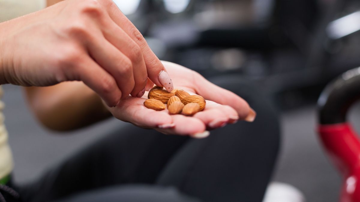 Frauenhand mit Mandeln Im Fitnessstudio