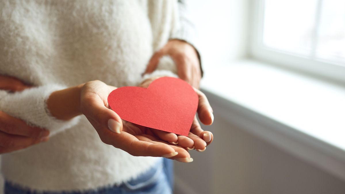 Red heart in the hands of a couple in love. St. Valentine's Day